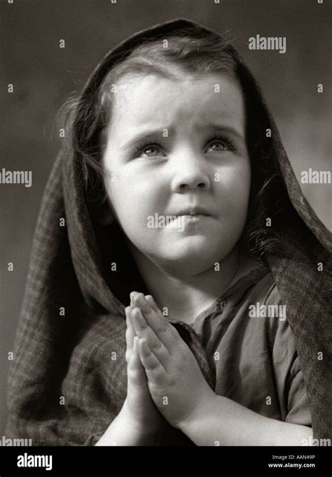 1930s Poor Sad Little Girl Shawl Over Hair Hands Praying Stock Photo