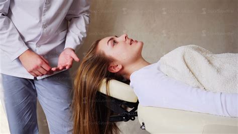 Handsome Guy Massage Therapist Doing Head Massage For Girl Client Who Lies On Couch In Doctors