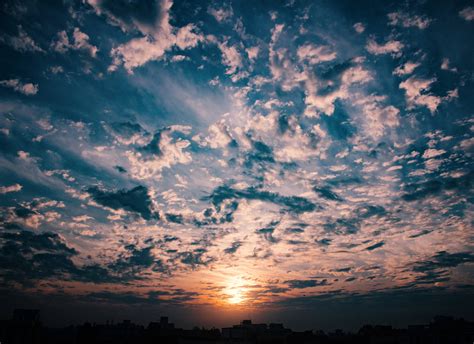 download the beauty of a golden hour sky with a backdrop of colorful clouds wallpaper