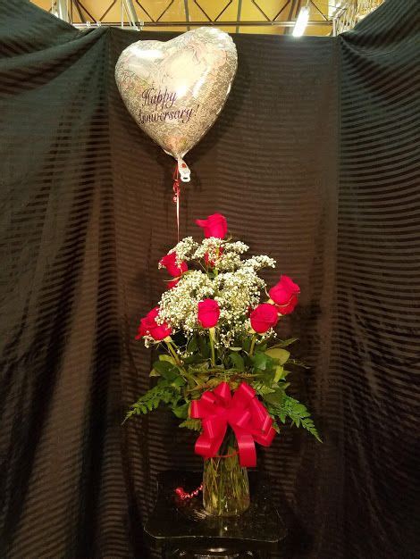 12 Red Roses Babys Breath And Greens In A Vase With A Red Bow And A
