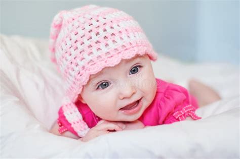 Newborn Baby Girl In Pink Knitted Hat On The Bed Stock Photo Image Of