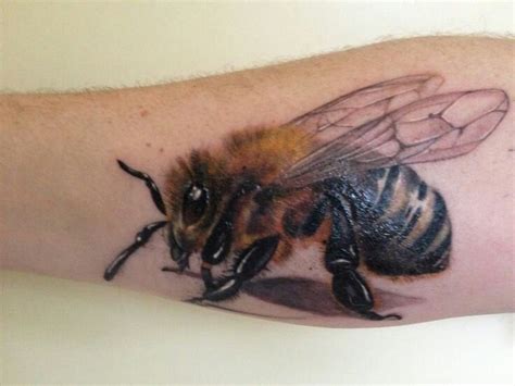 A Close Up Of A Persons Arm With A Tattoo Of A Bee On It