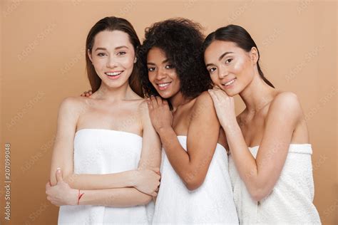 Three Smiling Naked Women Wearing In Towels Posing Together Stock Photo