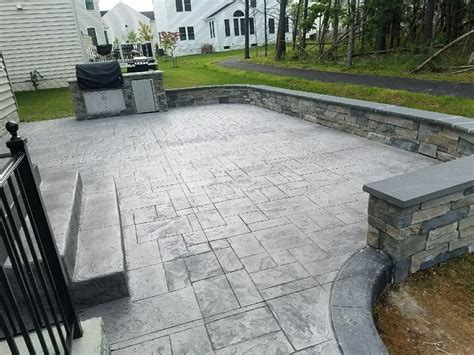 R Stamped Concrete Patio Seating Wall With Flagstone Caps And Dropped