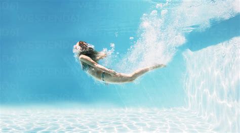 Woman Swimming Underwater In Swimming Pool Stock Photo