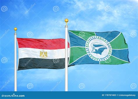 Egypt And Martinique Two Flags On Flagpoles And Blue Cloudy Sky Stock
