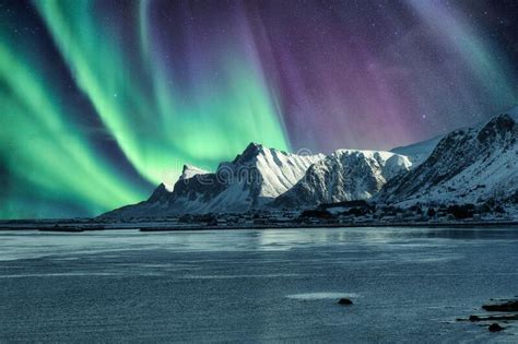 Aurora Borealis Northern Lights Above Of Snowy Mountain In Lofoten