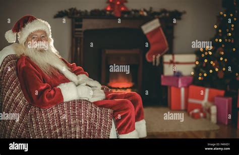 Festive Santa Claus Sitting On Couch At Christmas Stock Photo Alamy