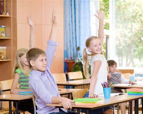 Children Raising Hands Knowing The Answer To The Question Stock Photo