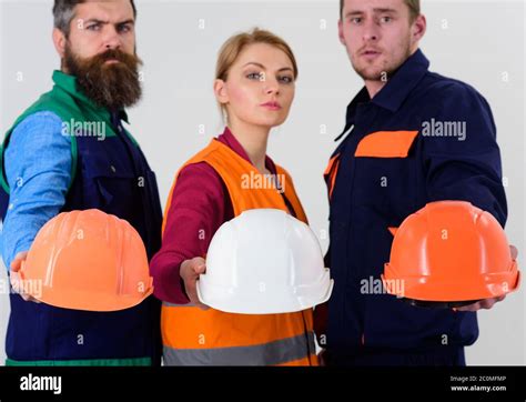 Men And Woman Wears Uniform And Holds Helmets Or Hard Hats Safety And Protection Concept Team