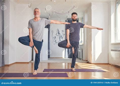 Men Standing On One Foot During The Balance Exercise Stock Photo