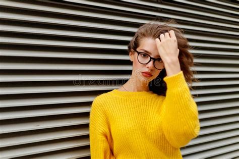 Trendy Hipster Girl In Knitted Yellow Sweater In Casual Fashion Outfit And Eyeglasses Posing