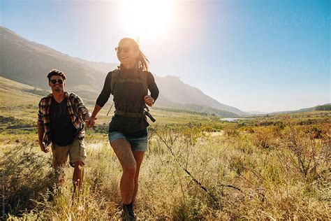 Happy Young Couple Hiking Together On A Summer Day By Jacob Lund