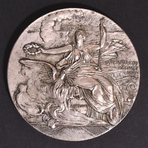 Το χρυσό μετάλλιο φόρεσε στο στήθος ο μίλτος τεντόγλου, λίγες ώρες έπειτα από τη μεγάλη νίκη του στον συγκλονιστικό τελικό του άλματος εις μήκος, στους ολυμπιακούς. 1906 - ΟΛΥΜΠΙΑΚΟΙ ΑΓΩΝΕΣ - ΑΡΓΥΡΟ ΜΕΤΑΛΛΙΟ ΣΥΜΜΕΤΟΧΗΣ