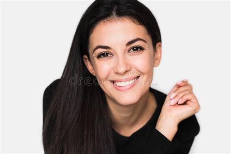 portrait de femme mignonne de brune avec le beau et sain sourire toothy avec la main sur le