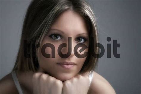 Young Woman Leaning On Her Chin Looking Into The Direction Of The C