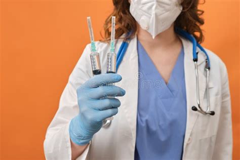 Woman Doctor Holds Syringes In His Hand On A Red Background Concept Female Nurse With Syringes