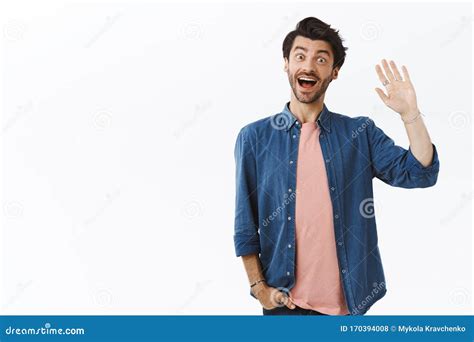 Friendly Good Looking Bearded Guy Saying Hi And Waving Raised Arm In