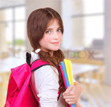 Side View Of Cute Teen Girl Standing In Classroom With