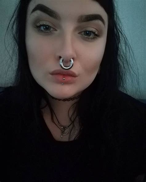 A Woman With Black Hair And Piercings On Her Nose Wearing A Fake Nose Ring