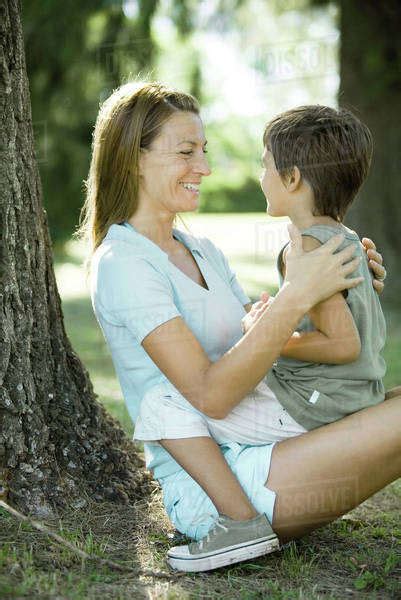 Mother And Son Outdoors Boy Sitting On Womans Lap Stock Photo