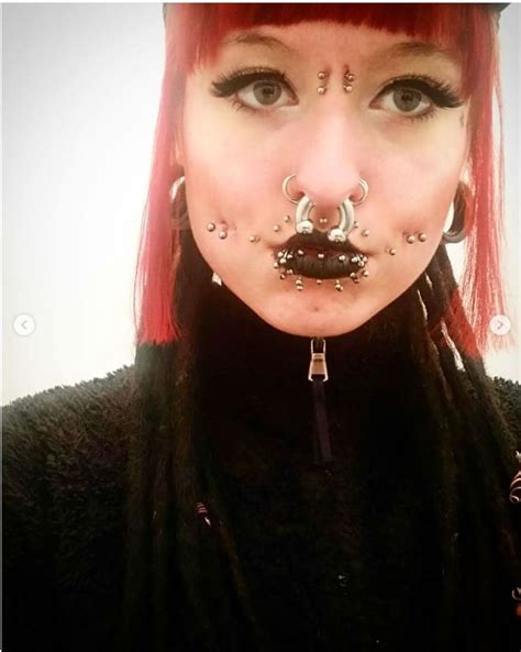 A Woman With Red Hair And Piercings On Her Nose