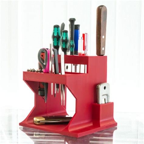 A Red Desk Organizer With Scissors And Other Office Supplies On Its Shelf