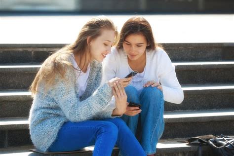 Dos Adolescentes Femeninos Felices Que Hablan Junto En La Calle Foto De Archivo Imagen De