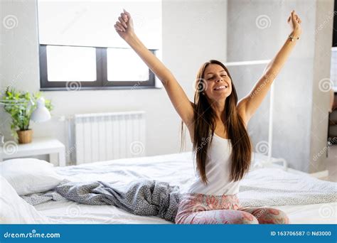 Beautiful Happy Young Woman Waking Up In The Morning And Stretching In