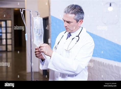 Male Doctor Checking A Saline Drip Stock Photo Alamy