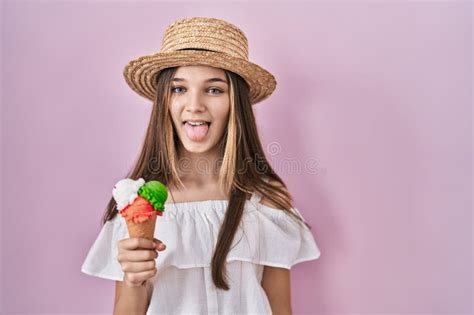Teenager Girl Holding Ice Cream Sticking Tongue Out Happy With Funny
