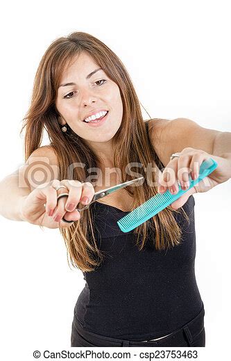 Young Pretty Smiling Female Hairdresser Using Comb And Scissors