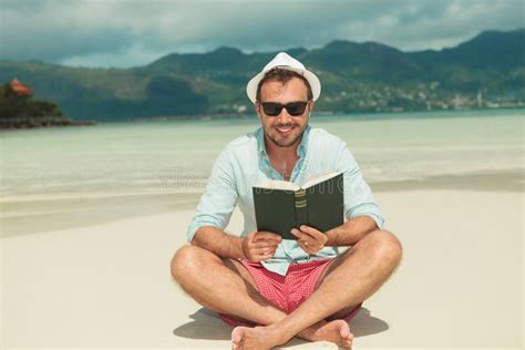 Man Smiling And On The Beach Enjoying Reading A Green Book Stock Photo Image Of Relax Seaside