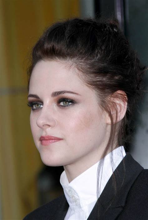 A Close Up Of A Person Wearing A Suit And Tie With Hair In A Bun
