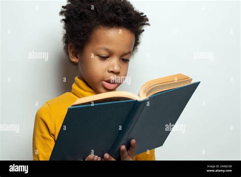Little African American Child Boy Reading A Book On White Background