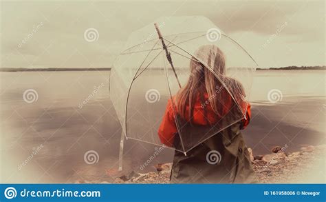 Girl On The Lake With An Umbrella In Bad Weather Stock