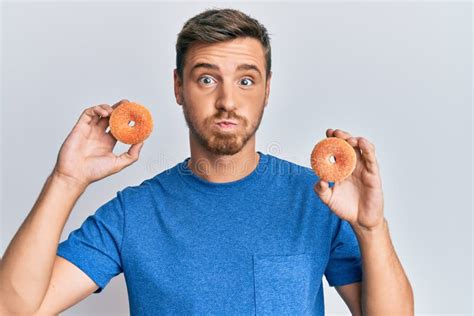 Handsome Caucasian Man Eating Donuts Puffing Cheeks With Funny Face