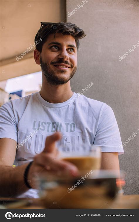 Young Man Drinking Coffee In Cafe — Stock Photo © Gorgev 319102826
