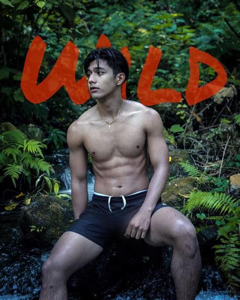 A Shirtless Man Sitting On Top Of A Rock In Front Of A Waterfall With The Word Wild Written Over It