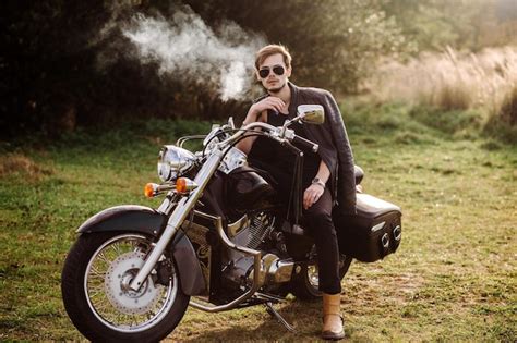Premium Photo Young Handsome Male Biker Is Sitting And Smoking On