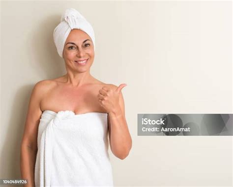 아름 다운 중 년 여자 젖은 머리 수건 손과 손가락으로 가리키는 행복 한 얼굴 미소를 입고 가리키기에 대한 스톡 사진 및 기타 이미지 Istock