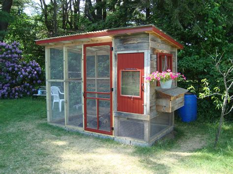 a chicken coop in the middle of a yard with purple flowers growing out of it