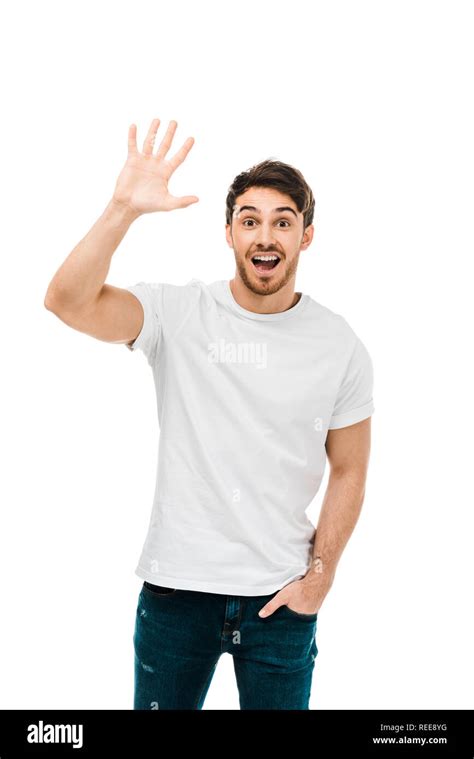 Cheerful Young Man Waving Hand And Smiling At Camera Isolated On White