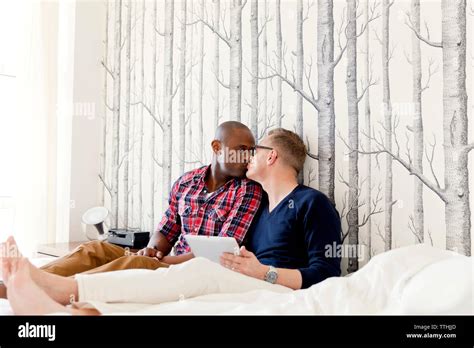 Los hombres gay besarse mientras descansa en la cama Fotografía de stock Alamy