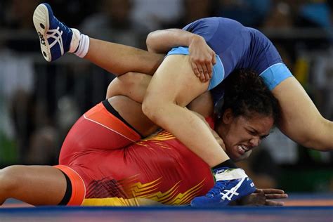 Two Women Wrestling On The Floor During A Competition