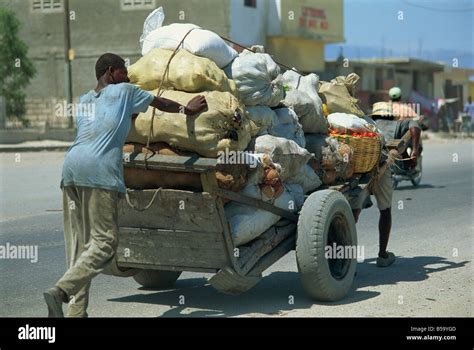 Men Pushing And Pulling Heavily Loaded Cart Along Road Port Au Prince