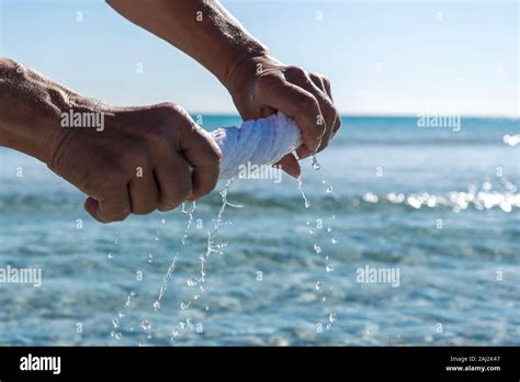 Hands Squeeze Wet Cloth At Sea Stock Photo Alamy
