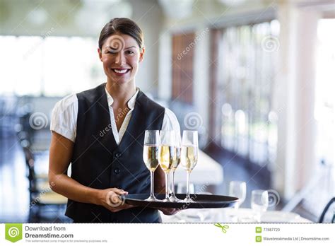Portrait Of Waitress Holding Serving Tray With Champagne FlutesÂ Stock