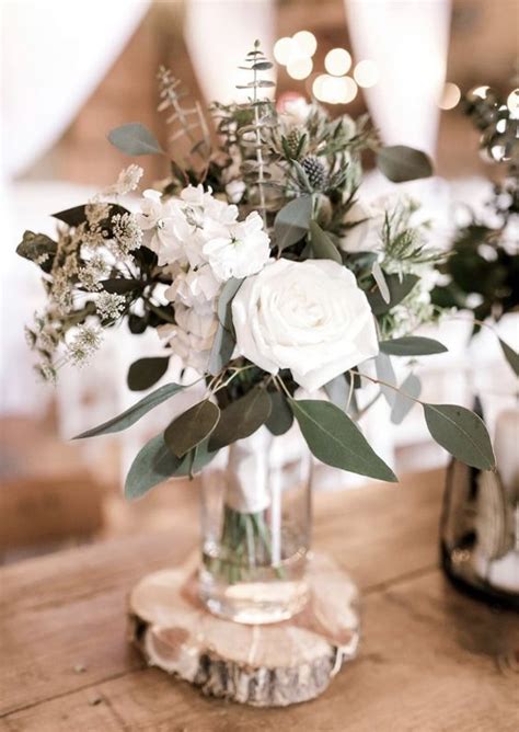 A Stylish Winter Wedding Centerpiece Of White Blooms Greenery And