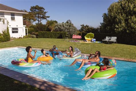Diverse Group Of Friends Having Fun Playing On Inflatables In Swimming Pool Stock Image Image